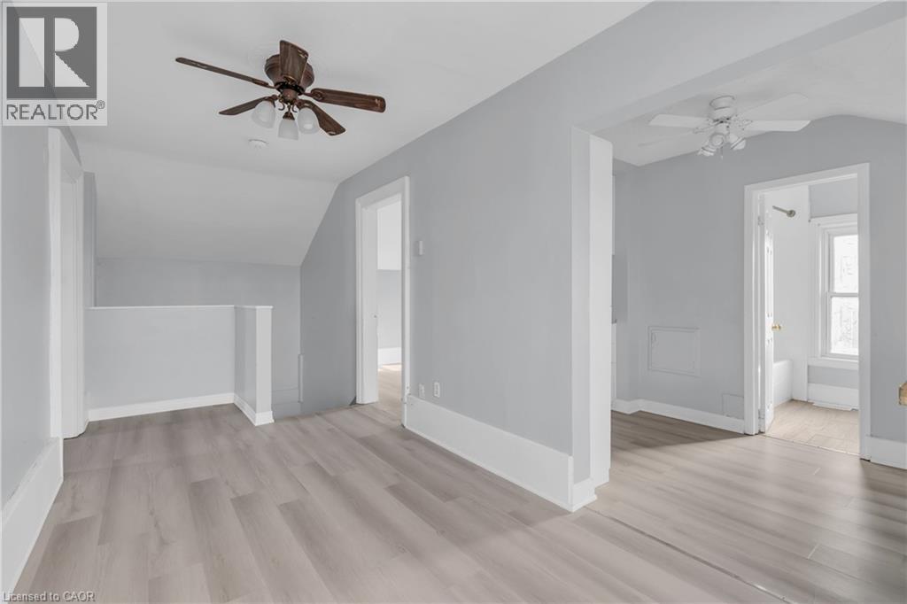 A spacious room with a ceiling fan and light fixture.