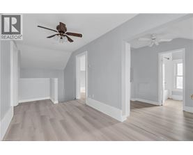 A spacious room with a ceiling fan and light fixture.