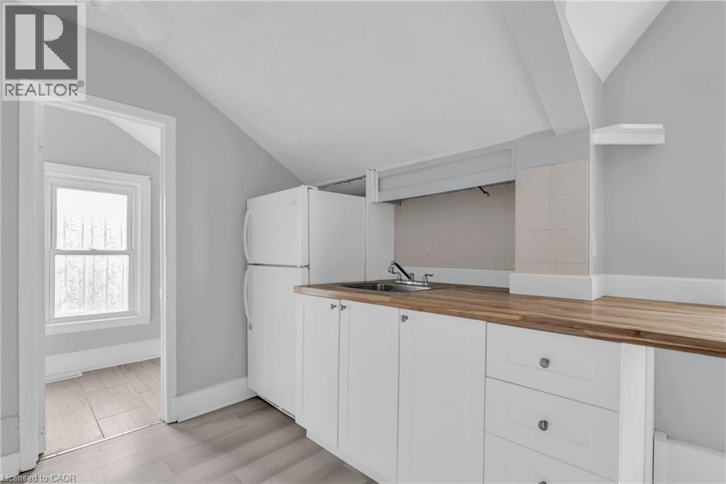 A kitchen with white cabinets and a wooden countertop.