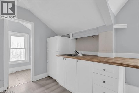 A kitchen with white cabinets and a wooden countertop.
