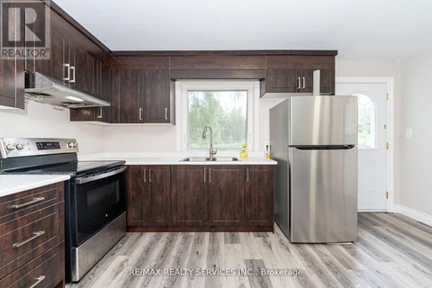 A kitchen with a stainless steel refrigerator and wooden cabinets.