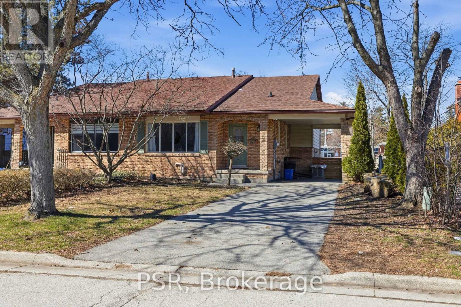 A house with a driveway and trees in front.