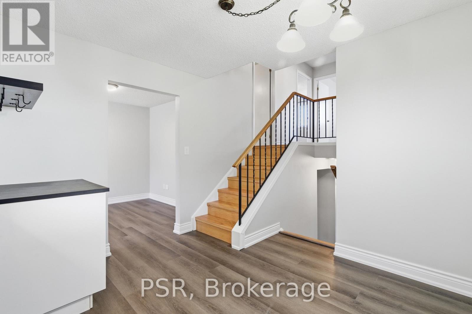 A well-lit, spacious hallway with a staircase leading to the second floor.