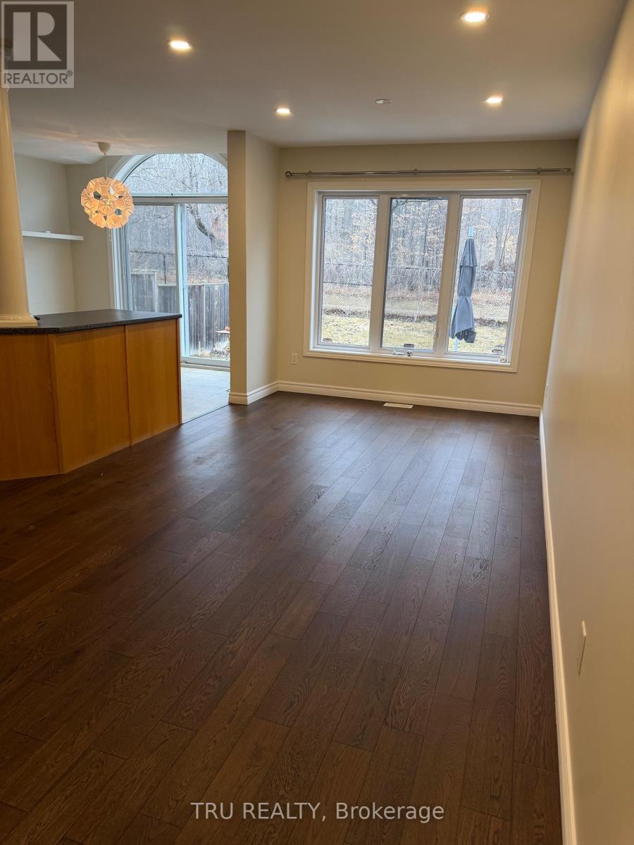 A room with wooden flooring and a large window.