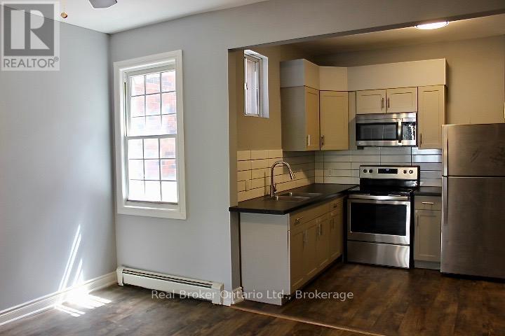 A kitchen with stainless steel appliances and wooden cabinets.