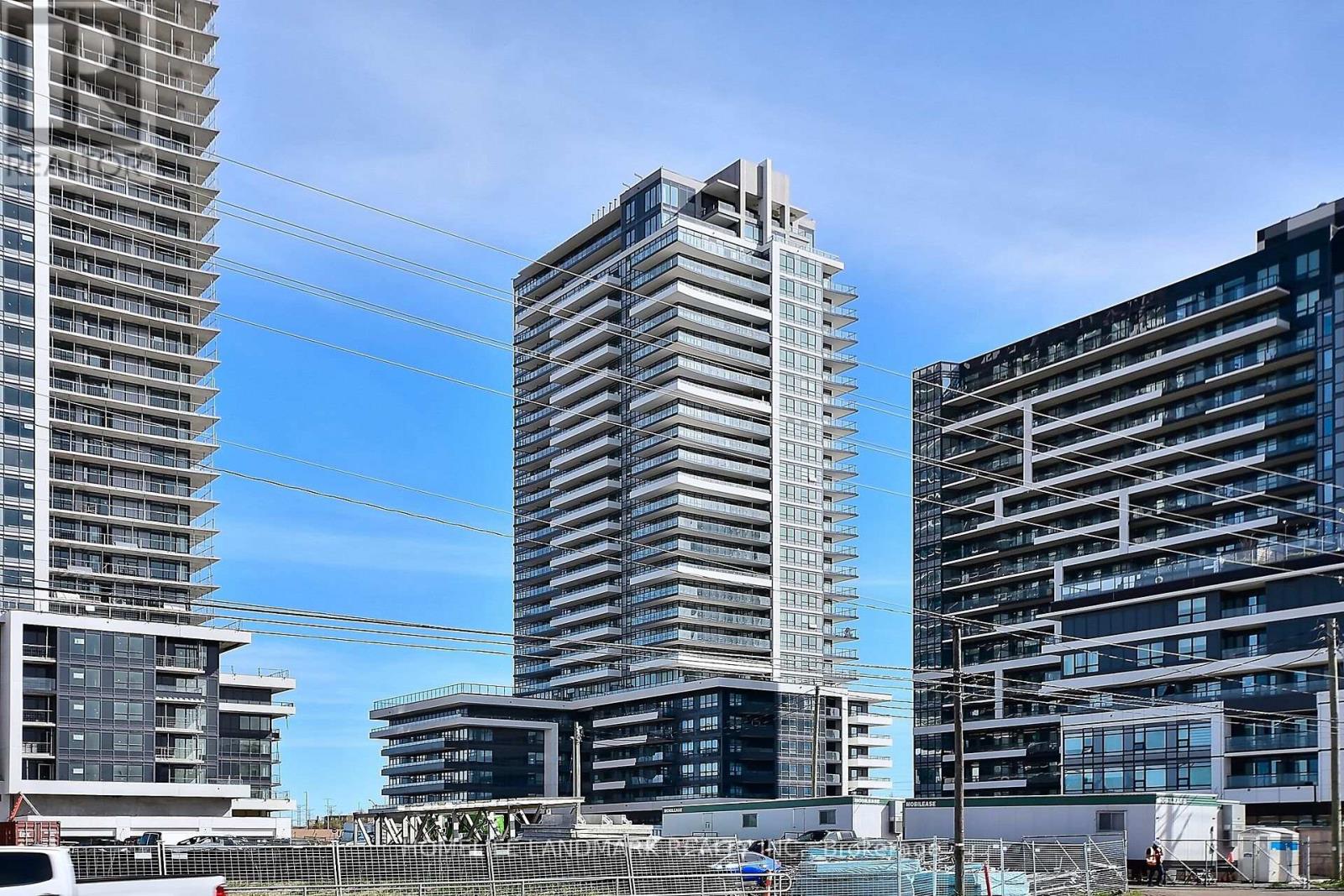 A cityscape with three tall buildings in the foreground and a clear blue sky above.