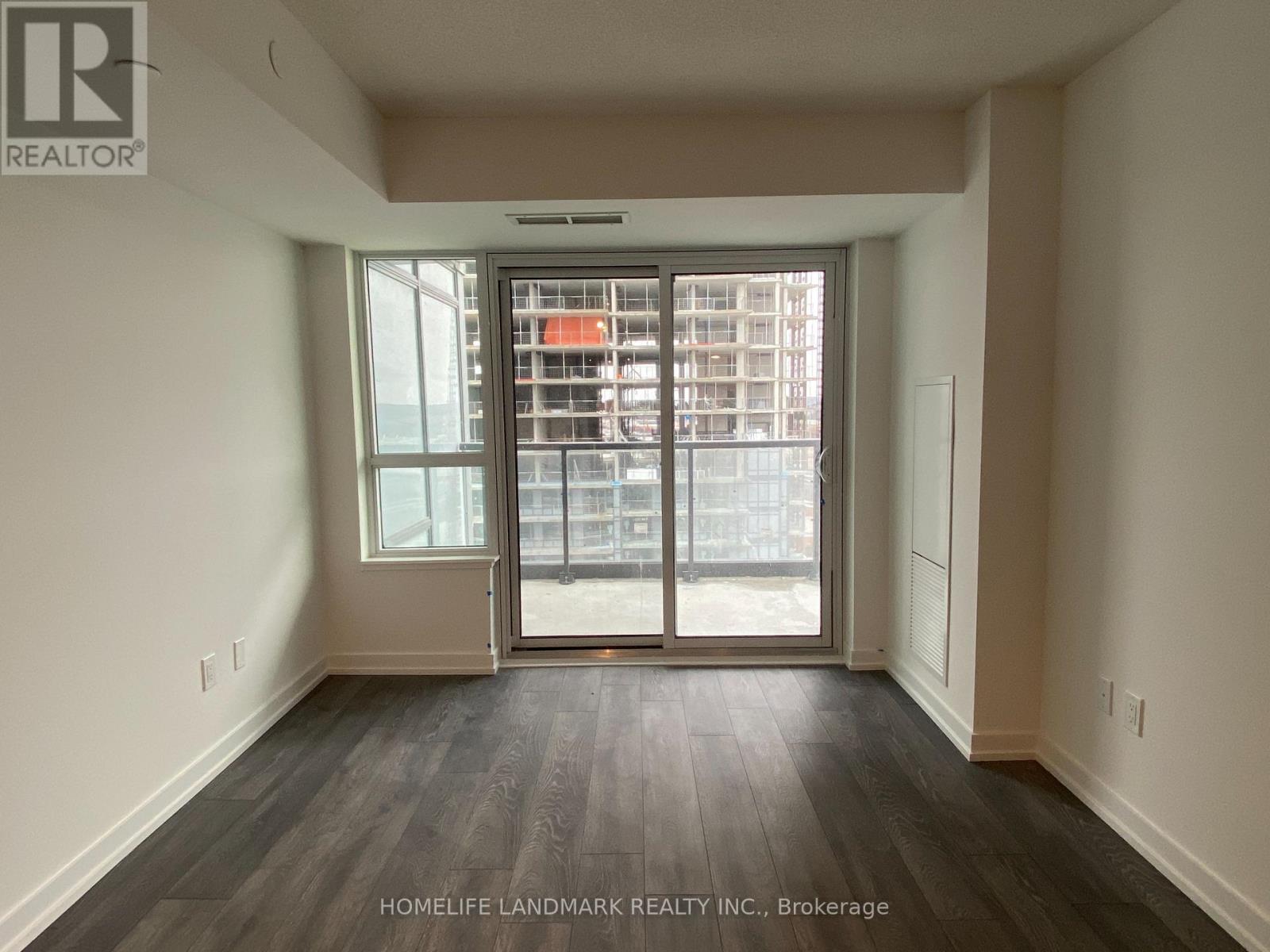 A room with a sliding glass door leading to a balcony.