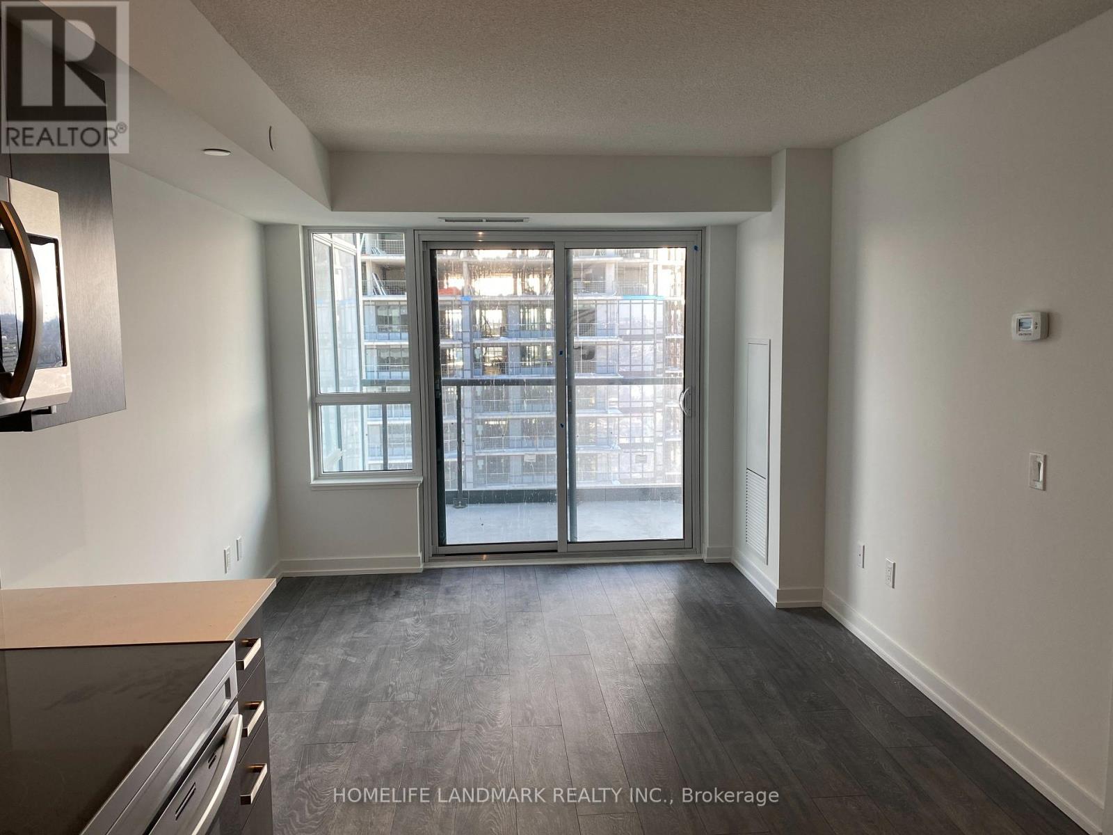 A spacious room with a large window and sliding glass doors.