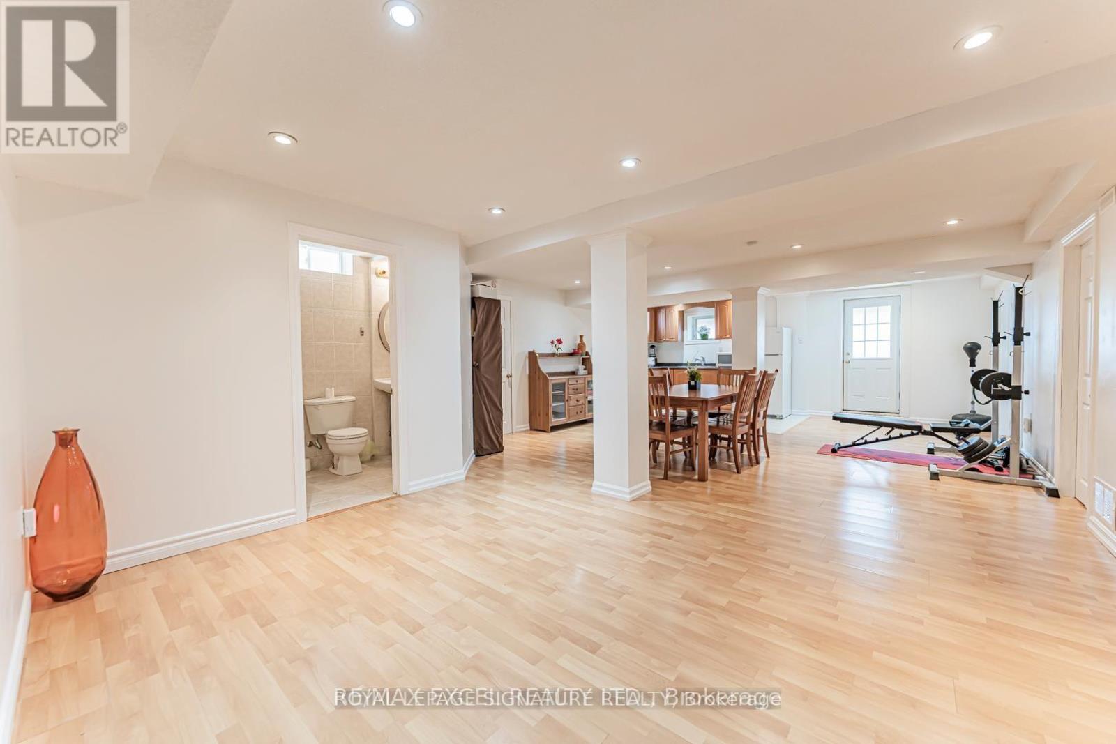 A spacious room with wooden flooring and white walls.