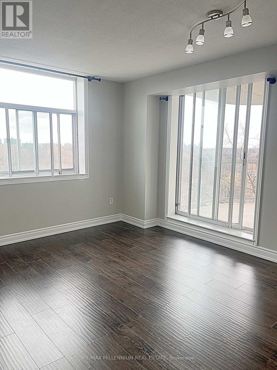 A room with wood flooring and a large window.