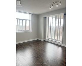 A room with wood flooring and a large window.