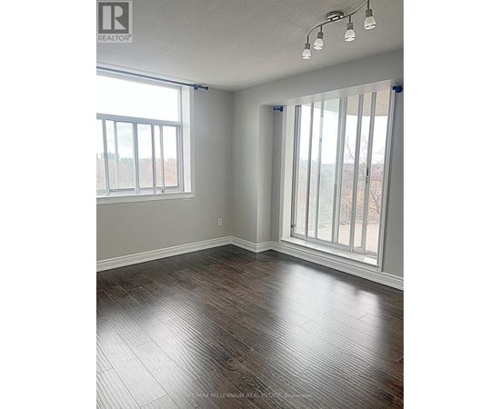 A room with wood flooring and a large window.