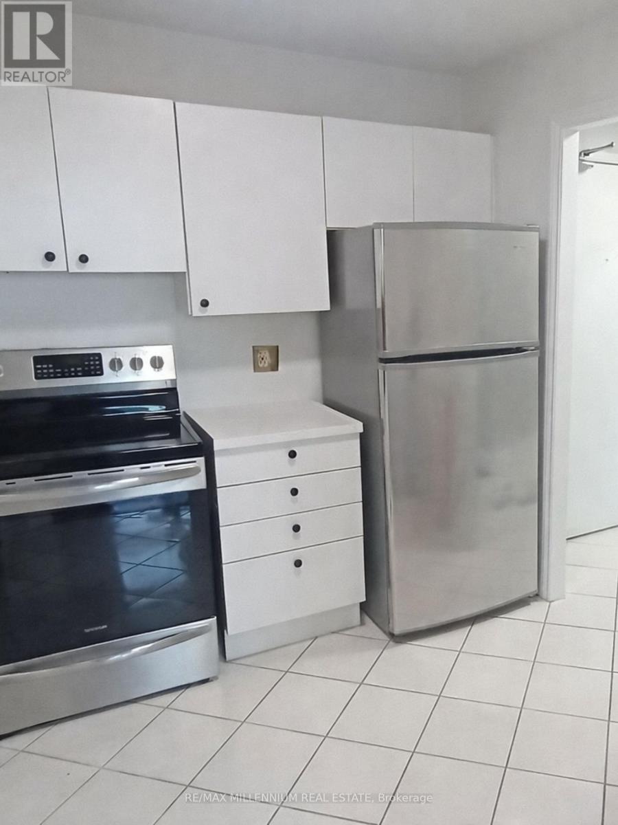 A kitchen with white cabinets and a stainless steel refrigerator and oven.