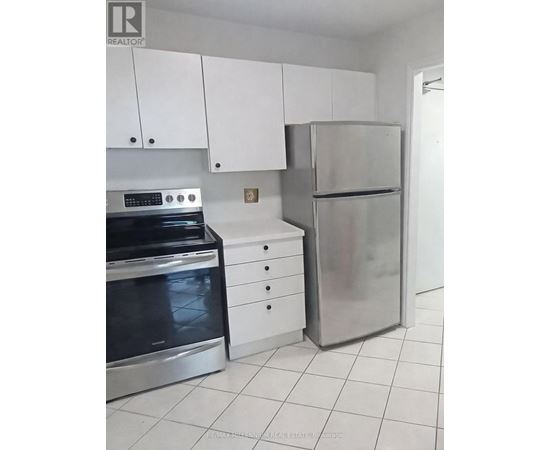 A kitchen with white cabinets and a stainless steel refrigerator and oven.