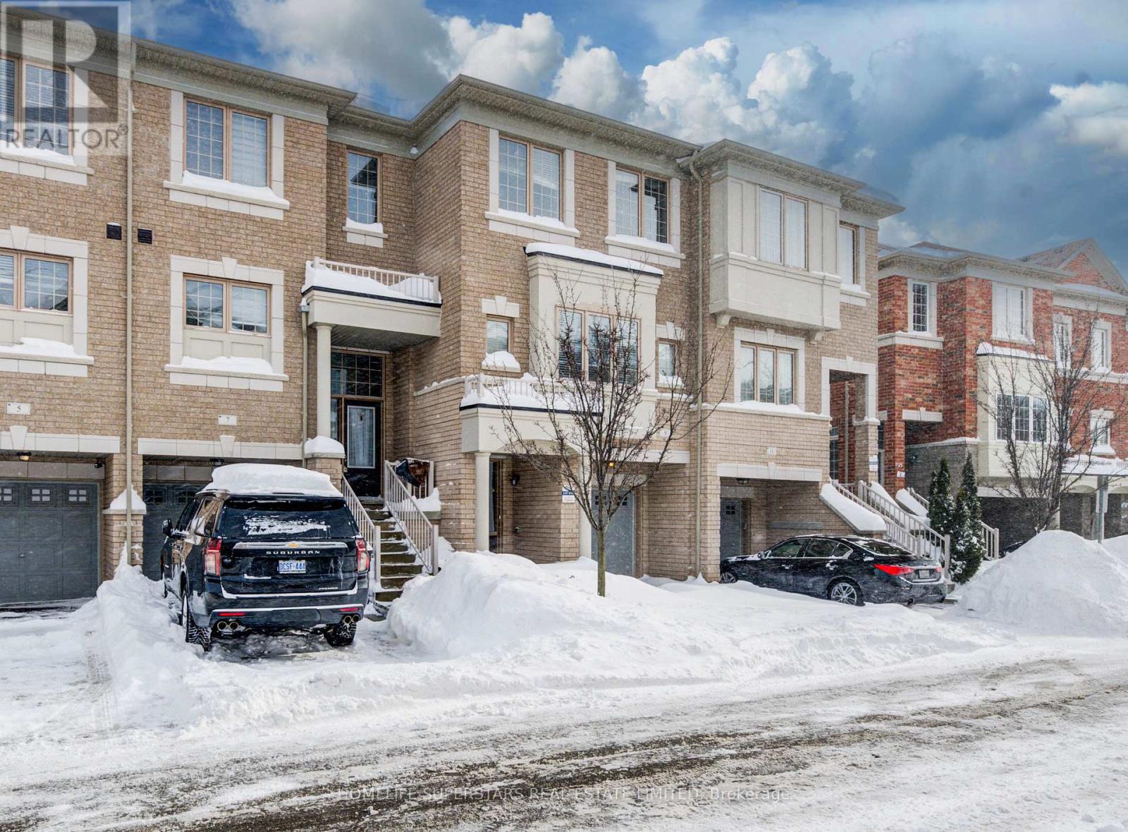 A black SUV is parked in front of a brick apartment building.