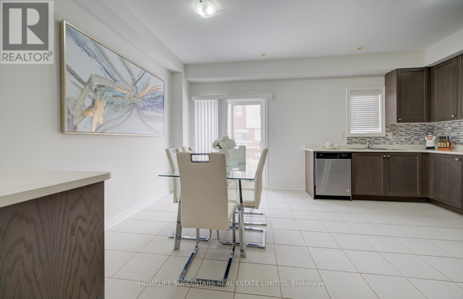 A kitchen with a dining table and chairs in the middle of the room.