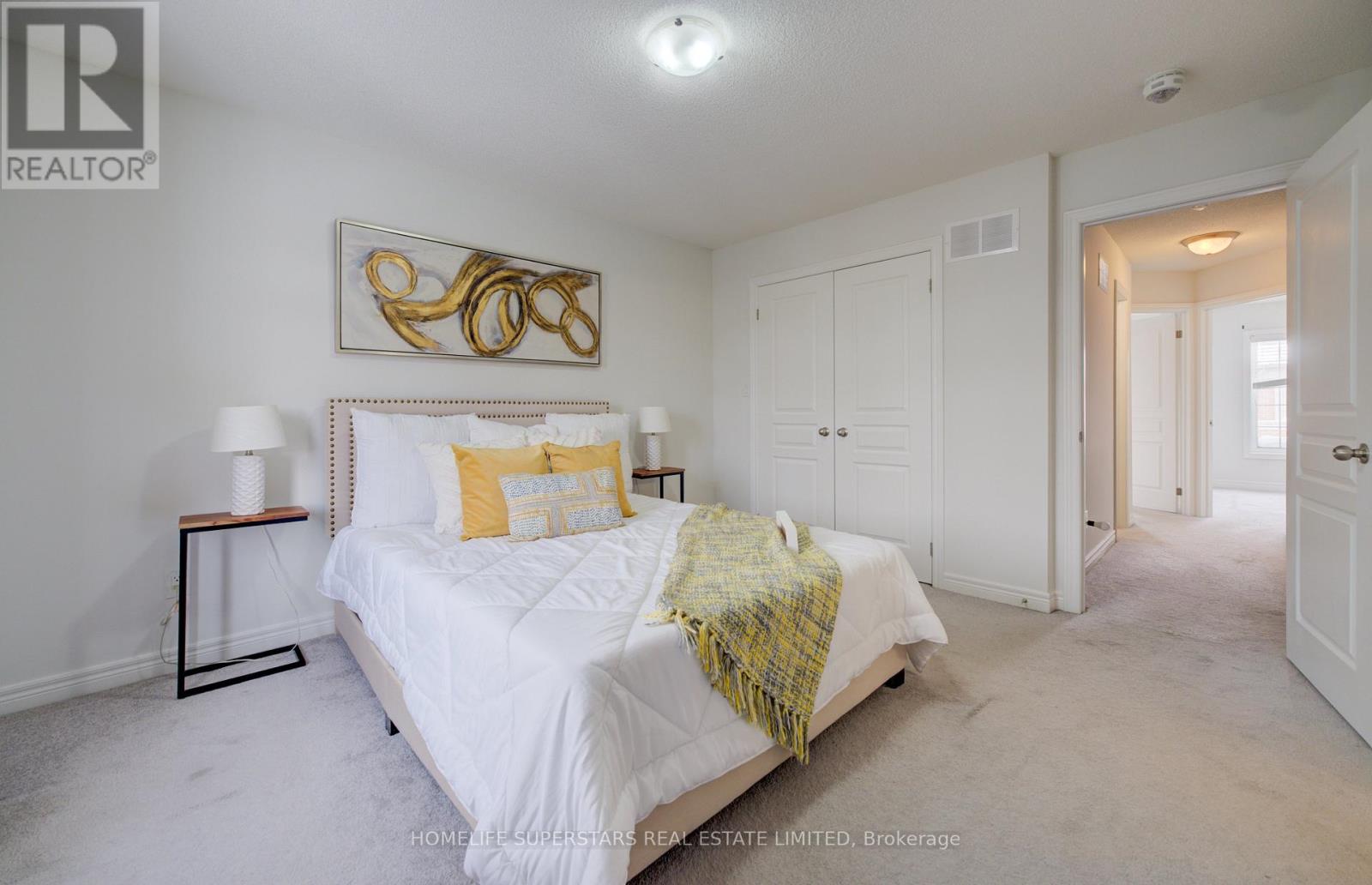 A bedroom with a white bed and a yellow throw blanket.