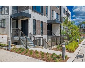 A modern brick apartment building with a well-maintained front yard.