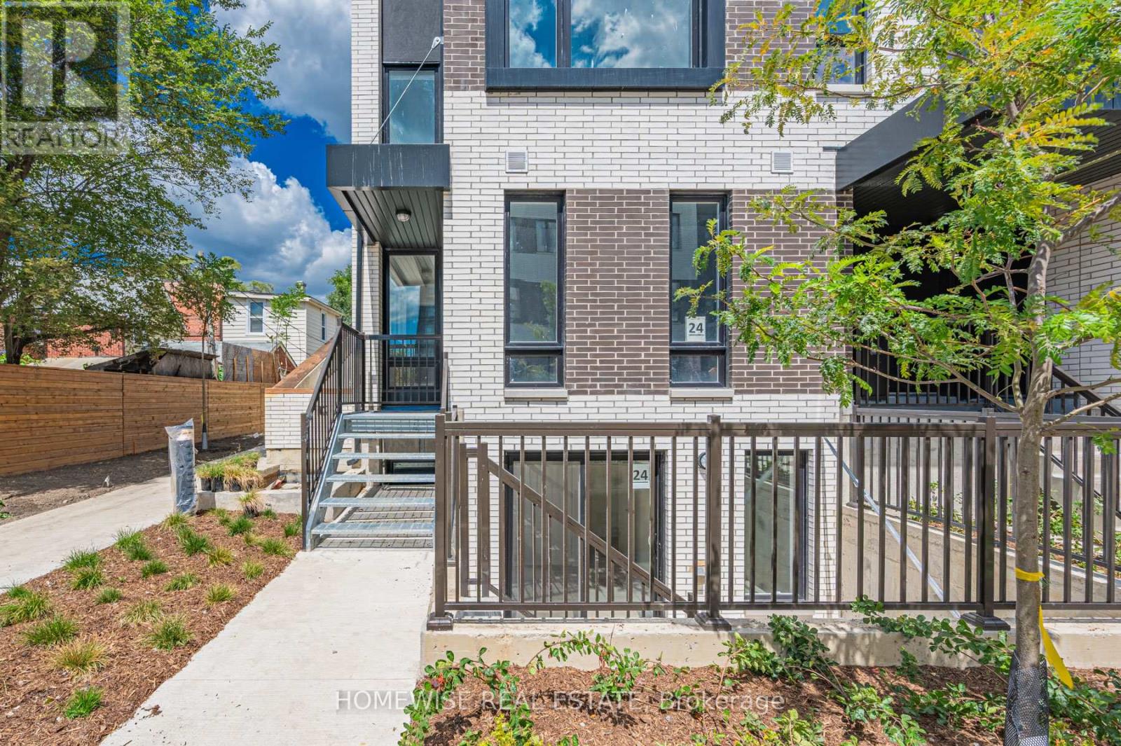 A modern house with a brick facade and a metal railing.