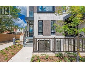 A modern house with a brick facade and a metal railing.