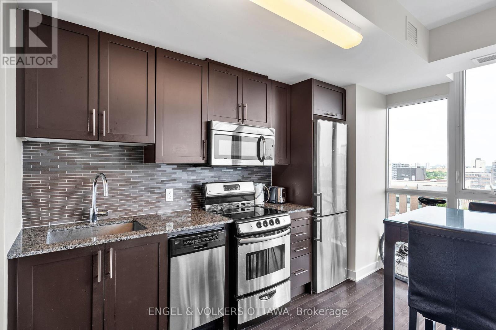 A kitchen with brown cabinets and stainless steel appliances.