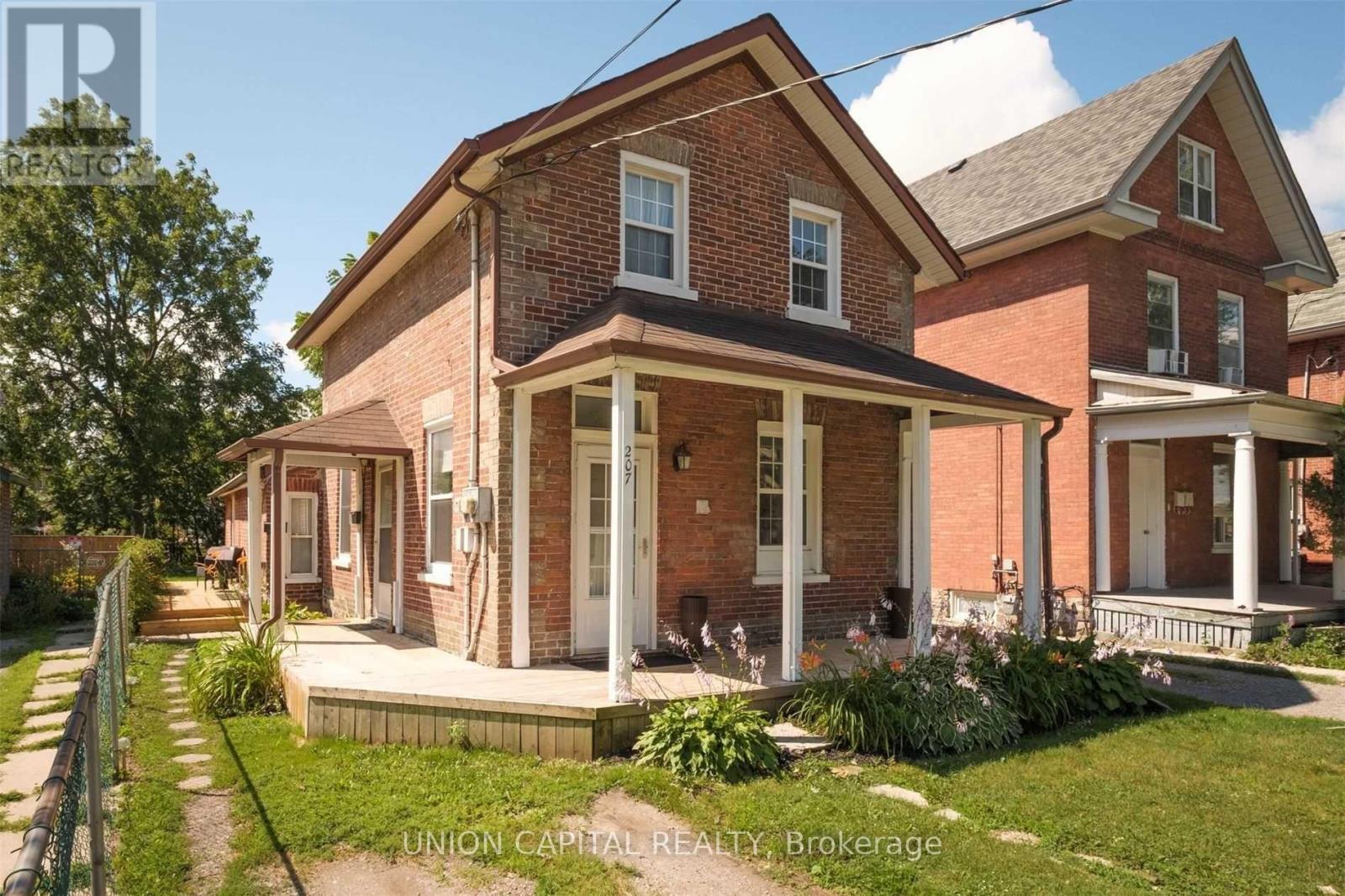 A brick house with a porch and a white door.
