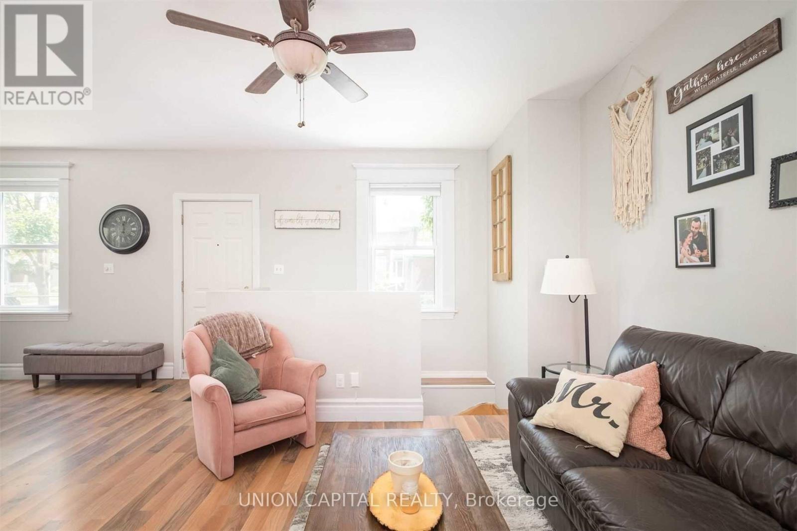A living room with a pink couch and a black couch.