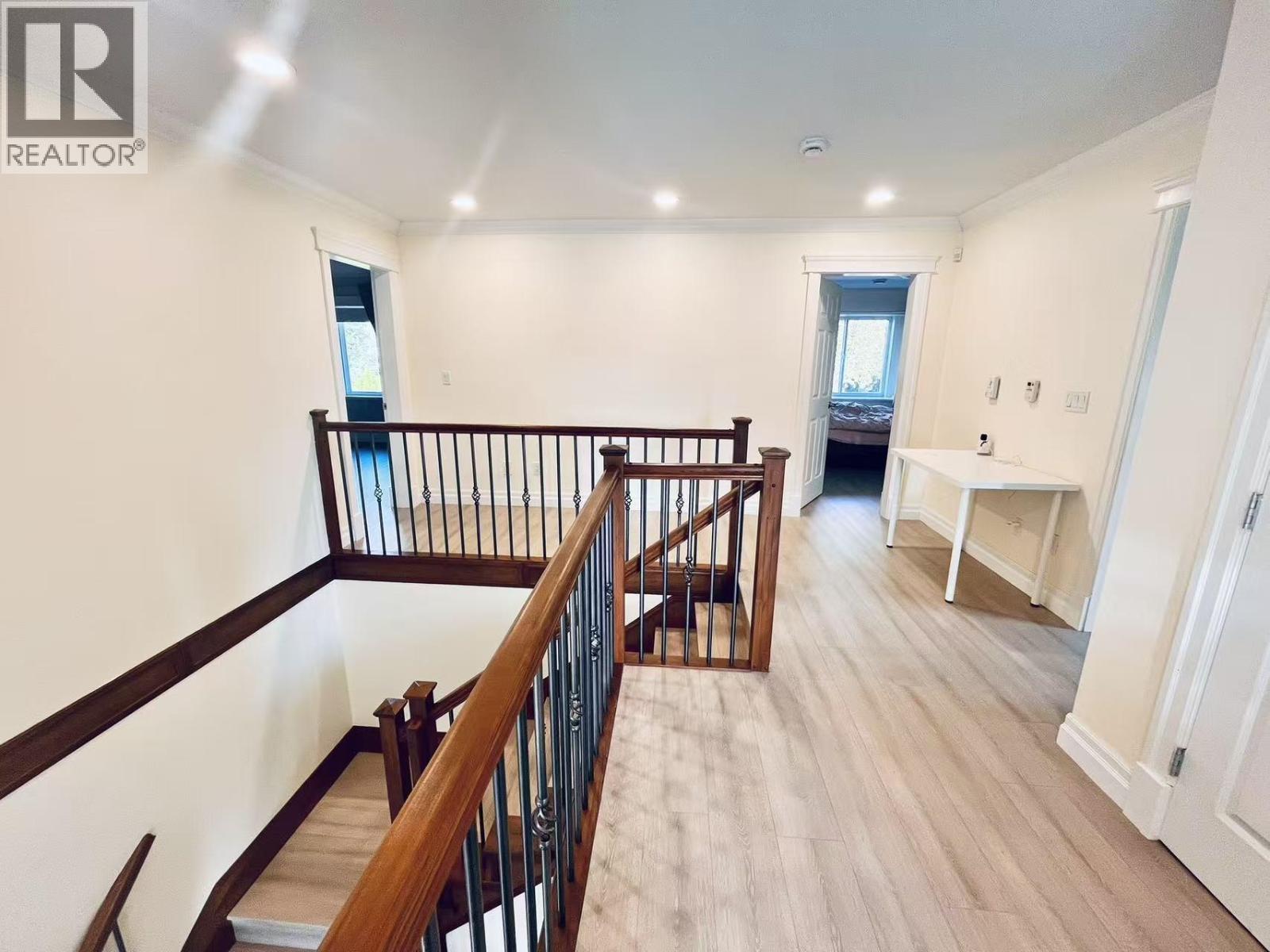 A well-lit, spacious room with a staircase leading to the upper level.