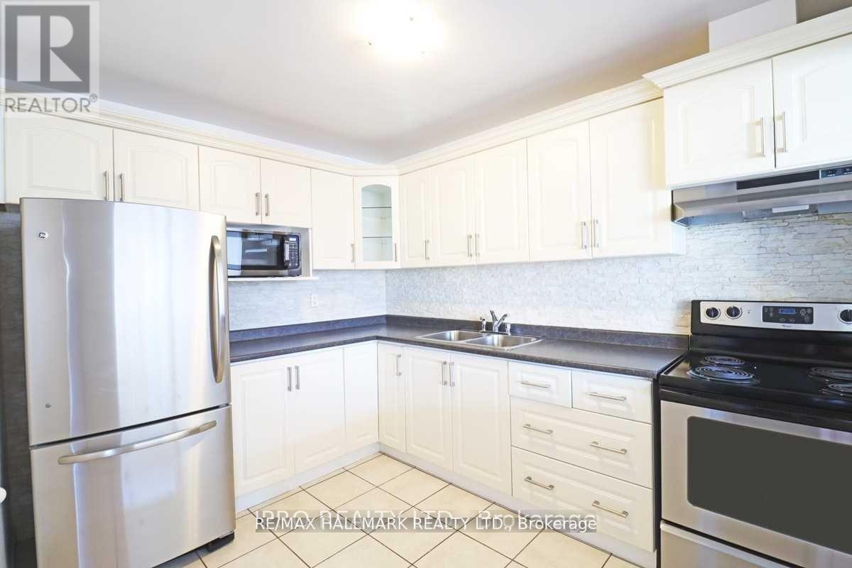 A kitchen with white cabinets and appliances.