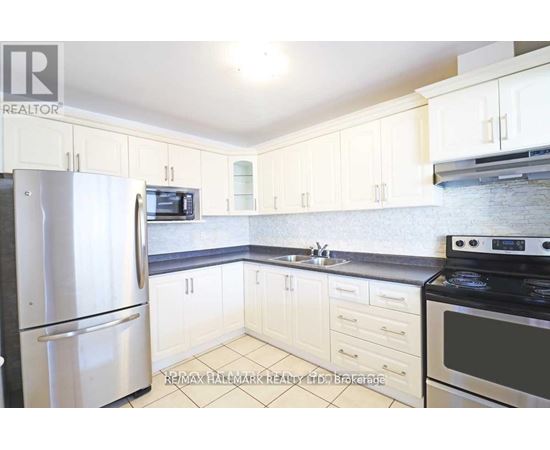 A kitchen with white cabinets and appliances.