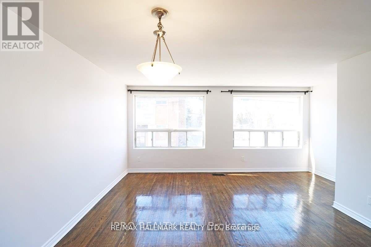 A room with a wooden floor and a chandelier hanging from the ceiling.