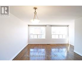 A room with a wooden floor and a chandelier hanging from the ceiling.