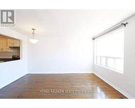 A room with a wooden floor and a window with blinds.
