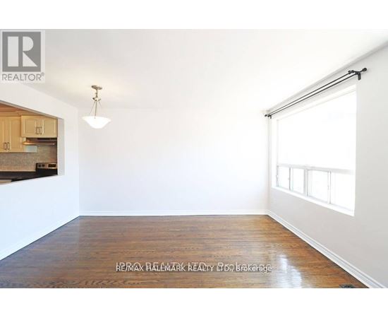 A room with a wooden floor and a window with blinds.