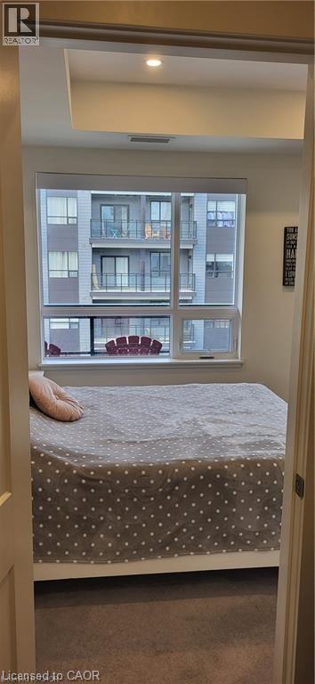 A bedroom with a bed and a window overlooking a building.