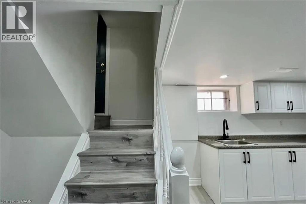 A staircase with wooden steps and a black door at the top.