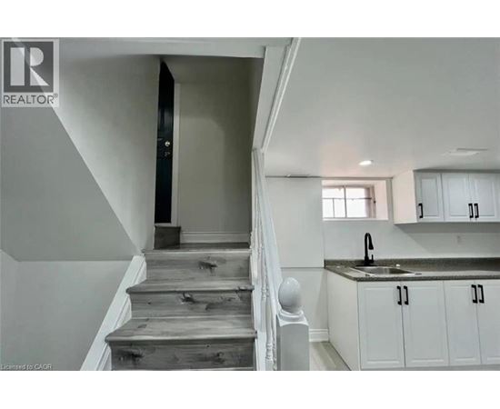 A staircase with wooden steps and a black door at the top.