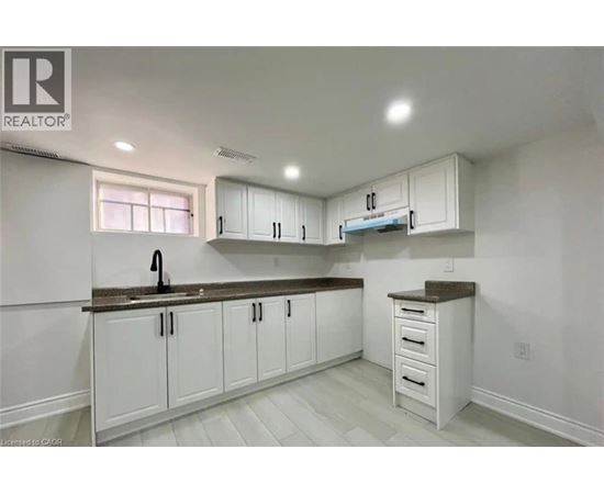 A kitchen with white cabinets and a brown countertop.