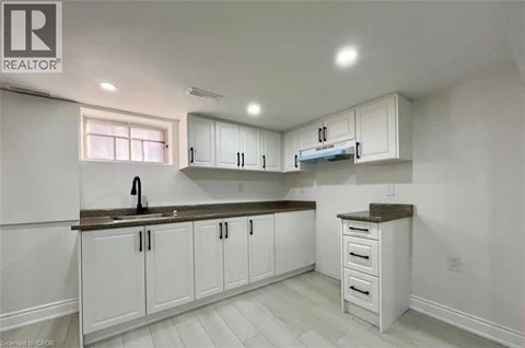 A kitchen with white cabinets and a brown countertop.