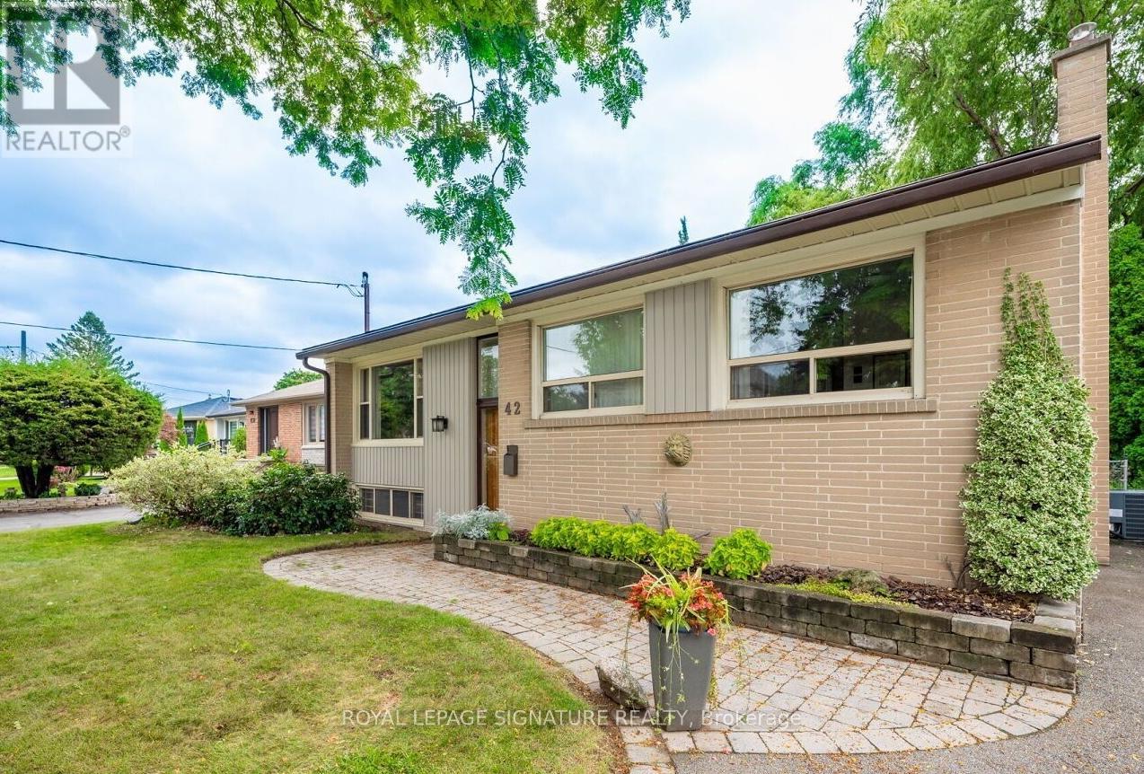 A house with a lawn and a potted plant in front.