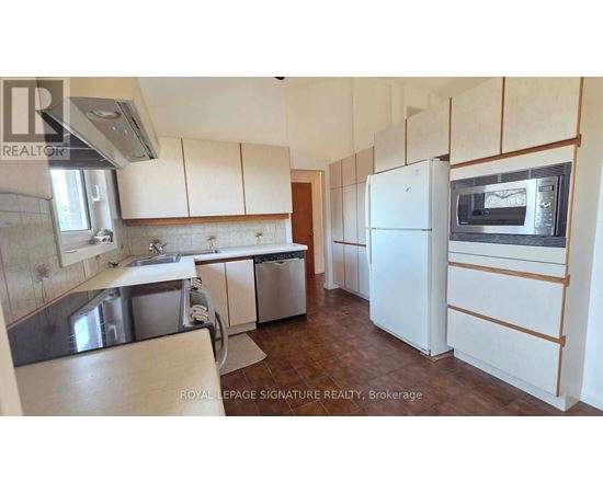 A kitchen with white cabinets and a white fridge.