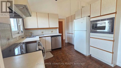 A kitchen with white cabinets and a white fridge.