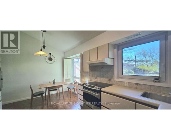 A room with a window showing a view of trees outside.