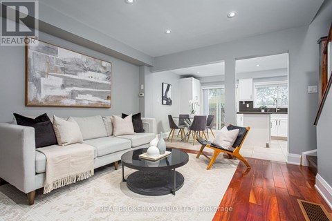 A living room with a grey couch, a coffee table, and a painting on the wall.
