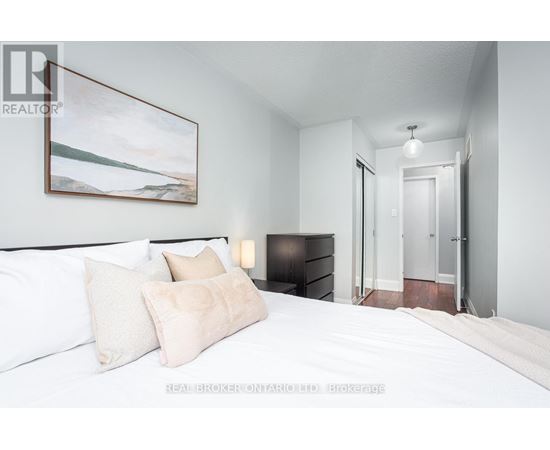 A bedroom with a large bed and a painting on the wall.