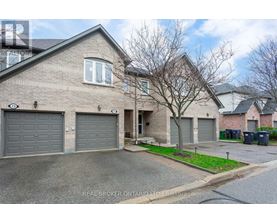 A house with a grey roof and a tree in front of it.