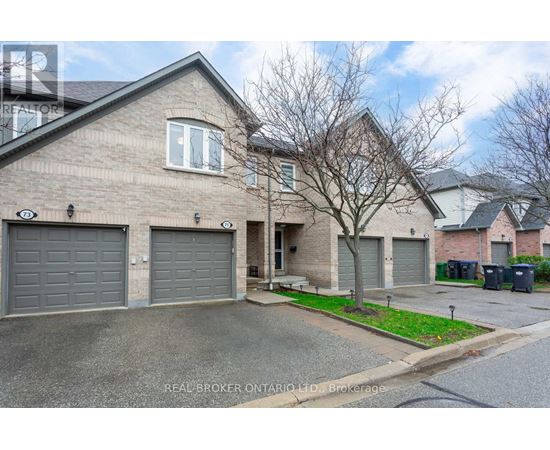 A house with a grey roof and a tree in front of it.