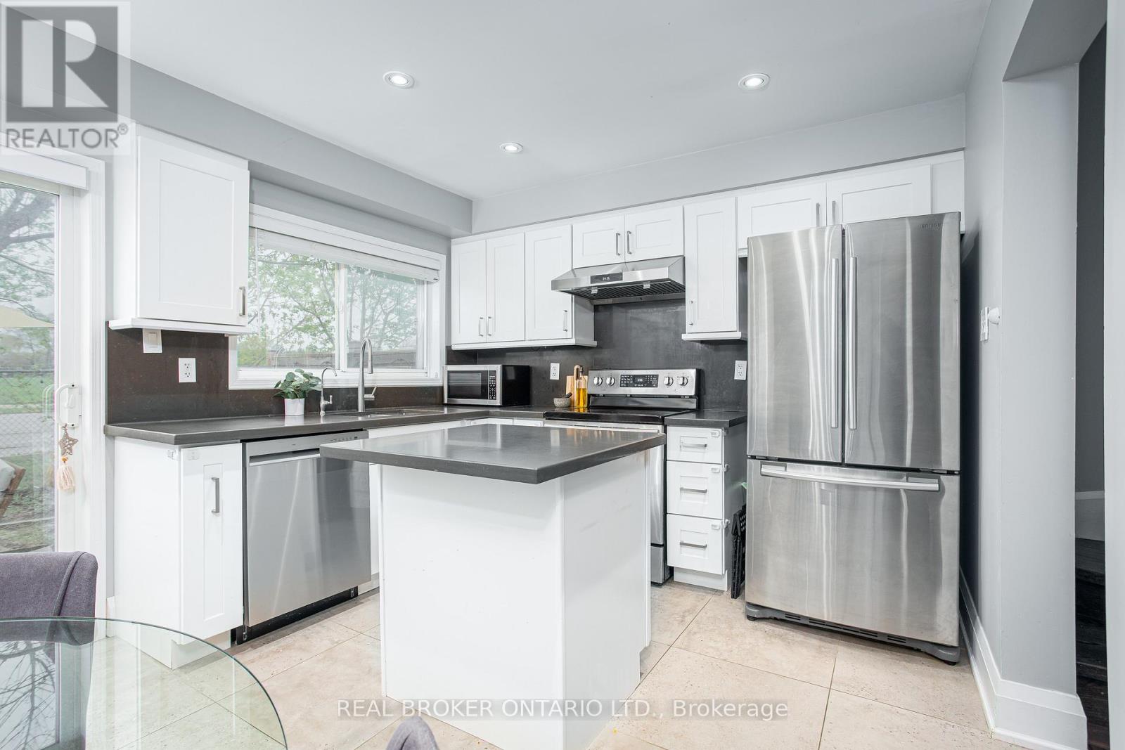 A modern kitchen with white cabinets and stainless steel appliances.