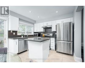 A modern kitchen with white cabinets and stainless steel appliances.