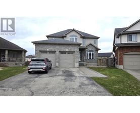 A grey house with a grey car in front of it.